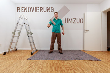 Renovierung / Umzug. Mann malt auf Konzepttafel.