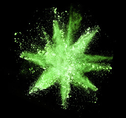 Explosion of green powder on black background