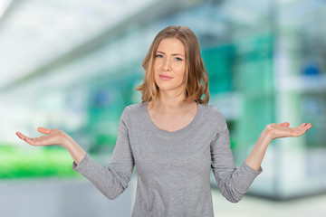 young woman with arms out shrugs shoulders