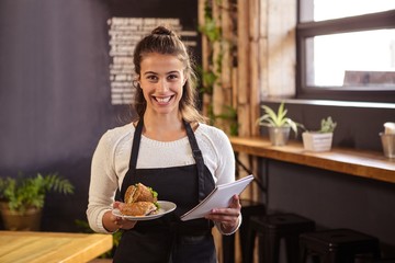 Waitress holding a plate and a clipboard 
