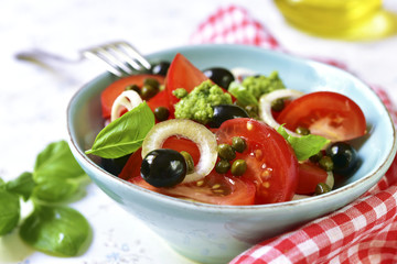 Tomato salad with capers,black olives,onion and sauce pesto.