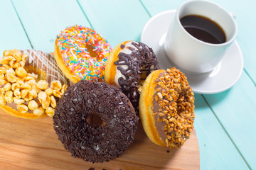 Donuts and coffee on wooden table. Top view