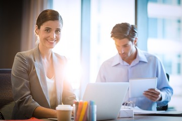 Obraz premium Businesswoman working on laptop with coworker