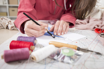 Fashion designer drawing in her fashion studio