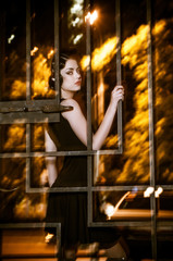 Pretty woman posing in cage outdoors at night