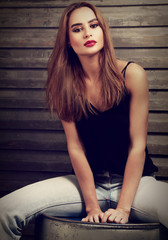 Naklejka premium Fashion makeup woman with long hair style in blue jeans and red
