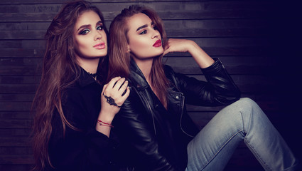 Fototapeta na wymiar Glamour makeup two women with long hair style sitting on street