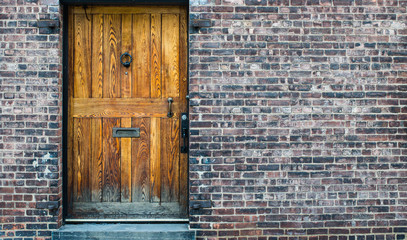 Solid vintage wooden door on classic brick wall texture background