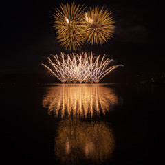 Colorful fireworks with reflection on lake.