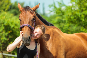Obraz premium Young woman girl taking care of horse.
