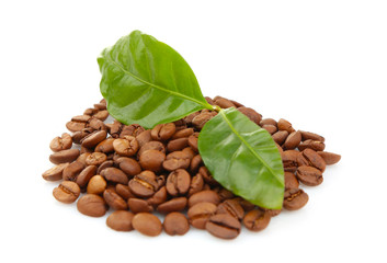 Coffee beans and green leaves, isolated on white