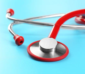 Red stethoscope on blue background