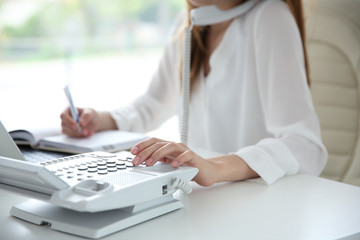 Businesswoman with office IP telephone