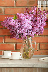 Bouquet of purple lilac flowers on brick wall background