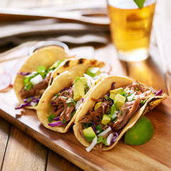 mexican pork carnitas tacos on yellow corn tortilla.