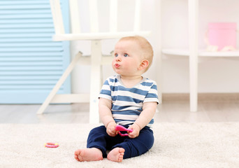 Adorable baby sitting on a carpet