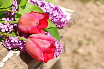 Beautiful fresh bouquet of violet lilac and red tulips