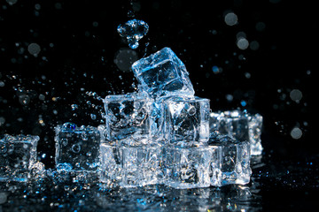 Group of ice cubes with water splashes.