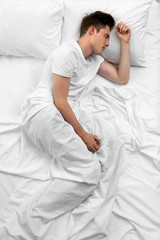 Handsome man in bed, top view