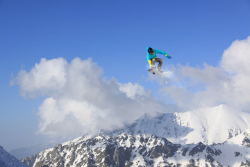 Naklejka na ściany i meble Snowboarder making high jump in cloudy sky.