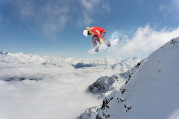 Naklejka na ściany i meble Snowboarder making high jump in cloudy sky.