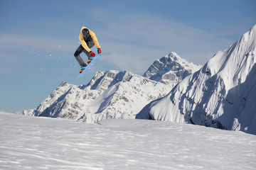 Snowboarder making high jump in cloudy sky.