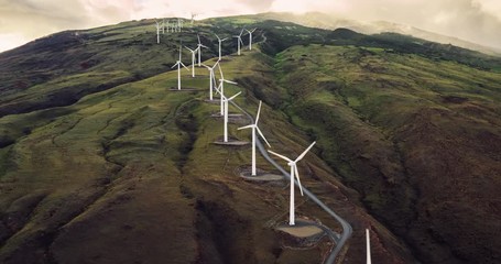 Aerial view of windmills turning at sunset, wind power turbines generate clean renewable energy - Powered by Adobe