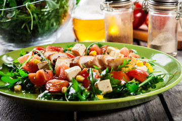Fresh salad with chicken breast, arugula and tomato