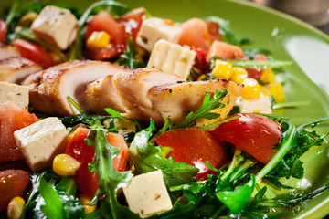 Fresh salad with chicken breast, arugula and tomato