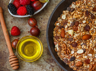Homemade granola with raisins, walnuts, almonds and hazelnuts. Muesli and honey . Fresh berries - raspberry, strawberry, gooseberry, mulberry. Healthy Breakfast. Top view