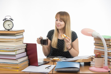 Sleepy student bites sandwich with coffee