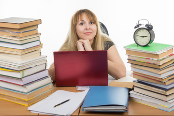 Disheveled student sitting at the table and looking at the frame