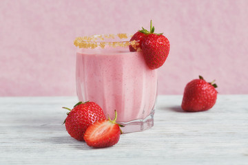 Strawberry smoothie or milkshake on white wooden background. Hea