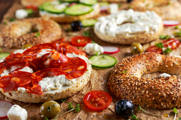 Delicious Bagel sandwiches with soft cheese, chorizo, vegetables. selected focus