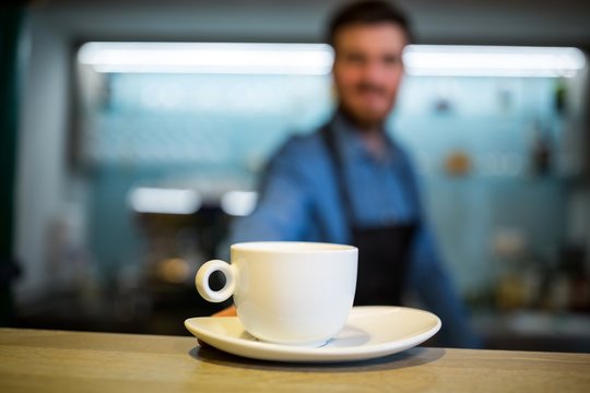 Waiter offering cup of coffee