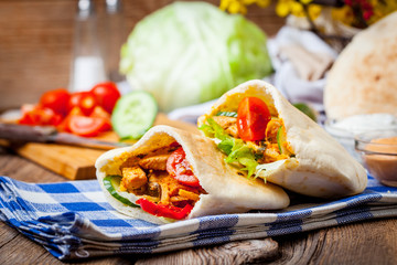 Fried chicken meat with vegetables in pita bread