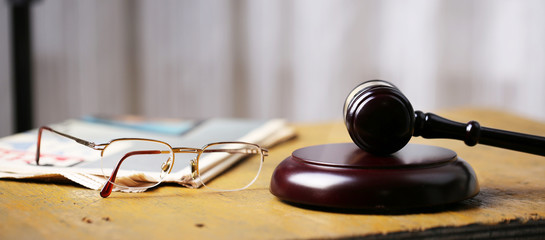 Labor law concept, gavel, glasses and newspaper on wooden table