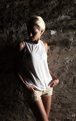 Lonely young woman standing on the street, looking severely depressed.