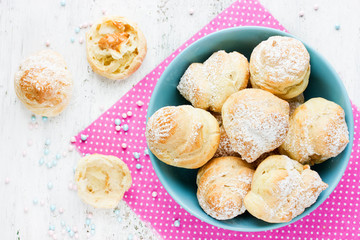 Eclairs with cream on white table