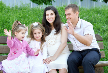 family on outdoor, pregnant woman with child and man, city park, summer season, green grass and trees