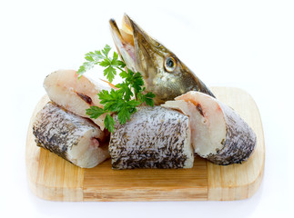 Pike fish pieces on wooden board isolated on white background