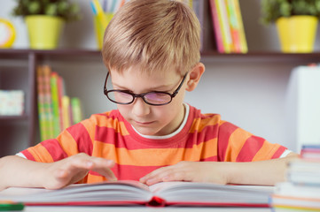  School boy at classroom desk making  schoolwork