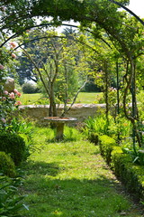 Roseraie avec table en pierre, jardin breton