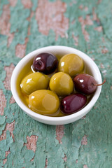 olives in a bowl on wooden surface