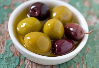 olives in a bowl on wooden surface