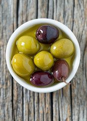olives in a bowl on wooden surface