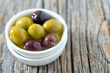 olives in a bowl on wooden surface