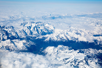 Alps with snow view through the white clouds
