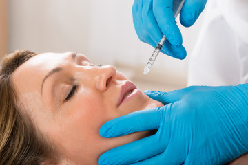 Woman Receiving Cosmetic Injection With Syringe
