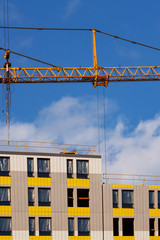 Crane and building site against blue sky
